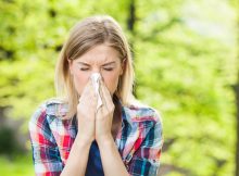 woman sneezing because of summertime allergies
