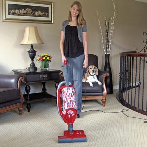 Girl using Red SEBO Felix 1 Upright HEPA Vacuum to vacuum