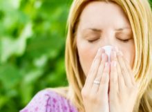 Allergy Medicine - Woman blowing her nose outside